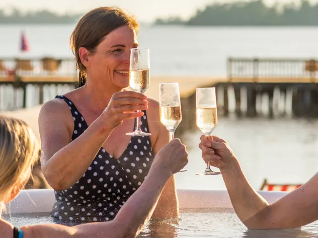 Kvinnor skålar i bubbelpoolen vid Carlsro Badhotell.