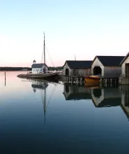 Sjöfararkapellet omgivet av skutor och båthus i Sjökvarteret i Mariehamn.